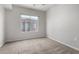 This is a bright bedroom with neutral walls and carpeting, a window, and no furniture at 1920 E Bell Rd # 1165, Phoenix, AZ 85022