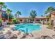 A beautiful community pool with lounge chairs, palm trees, and an adjacent building at 1920 E Bell Rd # 1165, Phoenix, AZ 85022