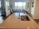 Bright kitchen island with a stainless steel sink and faucet, overlooking the dining area with large windows at 20952 E Via Del Sol --, Queen Creek, AZ 85142