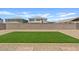This backyard features gravel landscaping and a green turf area surrounded by a block fence at 23038 E Twilight Dr, Queen Creek, AZ 85142