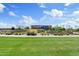 Community entrance with manicured landscaping and signage under a partly cloudy blue sky at 23038 E Twilight Dr, Queen Creek, AZ 85142