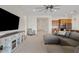 Spacious living room with a large TV, comfortable seating, and an open hallway at 23038 E Twilight Dr, Queen Creek, AZ 85142