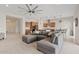 Open-concept living room and kitchen area featuring a large sectional sofa and wood cabinets at 23038 E Twilight Dr, Queen Creek, AZ 85142