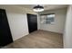A bright bedroom featuring light-colored wood floors, a dark accent door, and ample natural light at 3109 E Cholla St, Phoenix, AZ 85028