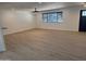 Inviting living room featuring stylish wood-look floors, a modern ceiling fan, and a large window for ample natural light at 3109 E Cholla St, Phoenix, AZ 85028