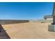 View of the spacious dirt backyard with a block wall at 35816 W San Ildefanso Ave, Maricopa, AZ 85138