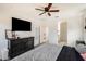 Comfortable bedroom with ceiling fan and dresser; ensuite bathroom visible through doorway at 35816 W San Ildefanso Ave, Maricopa, AZ 85138