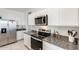 Bright kitchen features stainless steel appliances, granite countertops and white cabinetry at 35816 W San Ildefanso Ave, Maricopa, AZ 85138