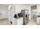 View of the kitchen featuring stainless steel refrigerator, granite counters, and white cabinets at 35816 W San Ildefanso Ave, Maricopa, AZ 85138