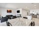 Open-concept living area with dining table, black leather sofas, and modern decor at 35816 W San Ildefanso Ave, Maricopa, AZ 85138
