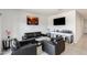 Modern living room features black leather furniture, tile flooring, and a wall-mounted television for a stylish and comfortable space at 35816 W San Ildefanso Ave, Maricopa, AZ 85138