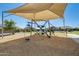 Community playground featuring a climbing structure on a wood chip base at 35816 W San Ildefanso Ave, Maricopa, AZ 85138