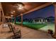Covered patio with rocking chairs overlooking lush backyard and gazebo at 3718 N Briere Ct, Buckeye, AZ 85396