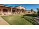 Expansive backyard featuring a well-maintained lawn, covered patio, and decorative pillars enhancing the outdoor space at 3718 N Briere Ct, Buckeye, AZ 85396