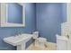 Stylish powder room with blue walls, pedestal sink, and modern fixtures at 3718 N Briere Ct, Buckeye, AZ 85396