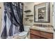Updated bathroom with granite countertop vanity, shower, and custom mirror and shelving at 3718 N Briere Ct, Buckeye, AZ 85396