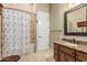 Traditional bathroom with a floral shower curtain, granite countertops, and tiled floors at 3718 N Briere Ct, Buckeye, AZ 85396