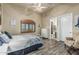 Bright bedroom featuring wood-look floors, ceiling fan, shutters, and attached bathroom at 3718 N Briere Ct, Buckeye, AZ 85396