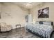 This bedroom features a ceiling fan, wood-look floors, accent chair, and neutral paint at 3718 N Briere Ct, Buckeye, AZ 85396