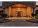Grand entryway with an arched stone facade, decorative lighting, and a welcoming front porch seating area at 3718 N Briere Ct, Buckeye, AZ 85396