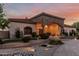 Beautiful exterior featuring stone accents, an arched entrance, and a meticulously landscaped front yard at 3718 N Briere Ct, Buckeye, AZ 85396