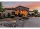 Stunning exterior view featuring a stone facade, arched entryway, and professionally landscaped front yard at 3718 N Briere Ct, Buckeye, AZ 85396