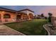 Sprawling backyard with lush lawn, covered patio, and custom landscaping at 3718 N Briere Ct, Buckeye, AZ 85396