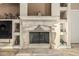 Elegant living room fireplace with travertine tile, built-in shelves, and decorative accents at 3718 N Briere Ct, Buckeye, AZ 85396