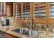 Kitchen with stainless steel sink, granite countertops, wood cabinets and shuttered window coverings at 3718 N Briere Ct, Buckeye, AZ 85396