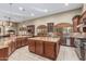 Spacious kitchen features custom cabinets, granite countertops, an island, and travertine floors at 3718 N Briere Ct, Buckeye, AZ 85396
