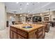Spacious kitchen island featuring wooden cabinetry and a stainless steel sink with travertine flooring at 3718 N Briere Ct, Buckeye, AZ 85396