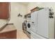 Functional laundry room with washer, dryer, countertop, and storage at 3718 N Briere Ct, Buckeye, AZ 85396