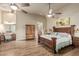 Bright main bedroom with wood floors features desk/vanity, ceiling fan, and sitting area at 3718 N Briere Ct, Buckeye, AZ 85396