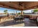 Outdoor living area featuring a dining table, seating, and a BBQ next to the pool and spa at 3718 N Briere Ct, Buckeye, AZ 85396