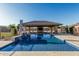 View of a refreshing pool with built-in water features and an adjacent outdoor entertaining space at 3718 N Briere Ct, Buckeye, AZ 85396