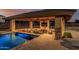 A covered outdoor entertaining space featuring a pool, seating area, and outdoor television for relaxation and enjoyment at 3718 N Briere Ct, Buckeye, AZ 85396