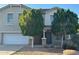 Two-story home with a blue door, white garage door, and desert landscaping at 38242 N Armadillo Dr, San Tan Valley, AZ 85140
