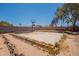 Spacious desert landscaped backyard with a basketball court, retaining walls, and desert plants at 4001 E Apollo Rd, Phoenix, AZ 85042
