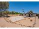 Large backyard with a concrete pad, mature trees, and desert landscaping, providing a serene outdoor space at 4001 E Apollo Rd, Phoenix, AZ 85042