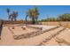 Spacious backyard with a basketball court, retaining walls, desert landscaping, and mature trees at 4001 E Apollo Rd, Phoenix, AZ 85042
