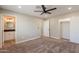 Spacious bedroom with carpet, a ceiling fan, and access to the ensuite bathroom and closets at 4001 E Apollo Rd, Phoenix, AZ 85042