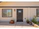 Close-up of the front door with security screen, surrounded by desert plants and decorative pots at 4001 E Apollo Rd, Phoenix, AZ 85042