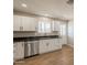 Well-lit kitchen with white cabinetry, stainless steel dishwasher, granite countertops, and tiled flooring at 4001 E Apollo Rd, Phoenix, AZ 85042