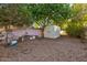 Gravel backyard featuring a storage shed and mature trees, offering a low-maintenance outdoor space at 4856 E Cheryl Dr, Paradise Valley, AZ 85253