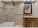 A well-lit bathroom featuring a shower-tub combo and a granite-topped vanity with dark cabinetry at 4856 E Cheryl Dr, Paradise Valley, AZ 85253