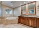 Luxurious bathroom featuring dual vanities, a soaking tub, and a large window, creating a spa-like retreat at 4856 E Cheryl Dr, Paradise Valley, AZ 85253