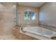 Elegant bathroom showcasing a soaking tub, walk-in shower, and natural light, perfect for relaxation at 4856 E Cheryl Dr, Paradise Valley, AZ 85253