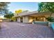 Single story home featuring covered patio with brick pavers and benches at 4856 E Cheryl Dr, Paradise Valley, AZ 85253