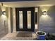 An elegant doorway is flanked by sconces and framed with sleek sidelights at 4856 E Cheryl Dr, Paradise Valley, AZ 85253