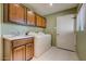 Well-lit laundry room with washer, dryer, sink and storage at 4856 E Cheryl Dr, Paradise Valley, AZ 85253